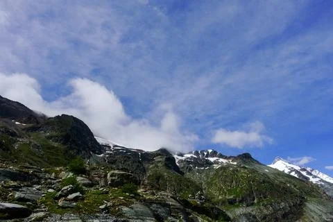 Dense clouds on the blue sky while hiking in the mountains Stock Photos