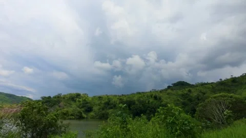 Dense clouds build rapidly over green hills and water at Presa El Carrizo Video stock 325383410