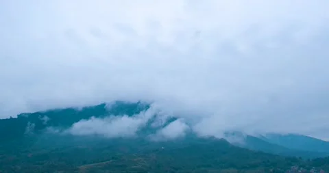 Dense Clouds Drifting Over Lush Green Mountain Peaks During A Misty Morning Stock Footage 342090859