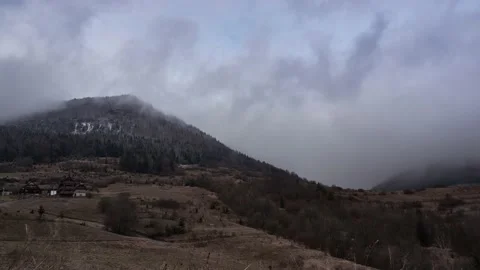 Dense clouds moving around a rocky hill at sunset in cloudy weather Stock-Footage 146280782