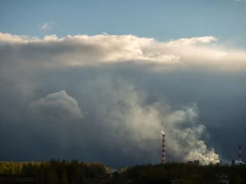 Dense clouds of smoke or a pair of two pipes against a cloud background. The  Foto stock