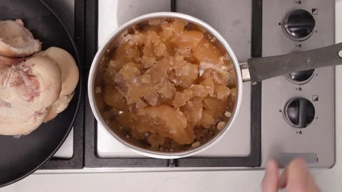 Dense, collagen-rich bone broth with a gelled texture tested by spoon on the Stock Footage 344032085