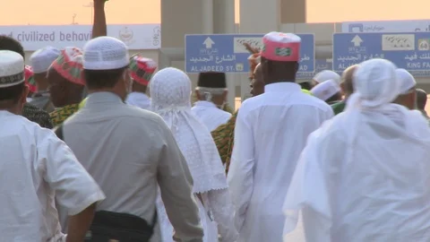 Dense crowd of Muslims walking through streets of Mina during Hajj, sunset Stock Footage 86760180