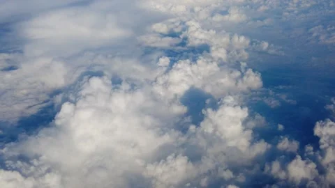 Dense cumulus cloud carpet stretches to horizon scattered gaps reveal deep blue Stock Footage 343672851