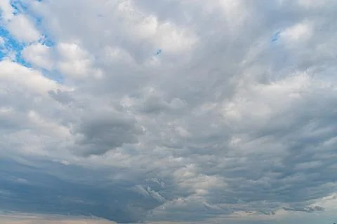 Dense, dark clouds hinting at an impending storm against a few patches of blu 写真素材