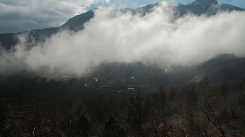 Dense fog envelops valley with a graying among mountains. Stock Footage 79902886