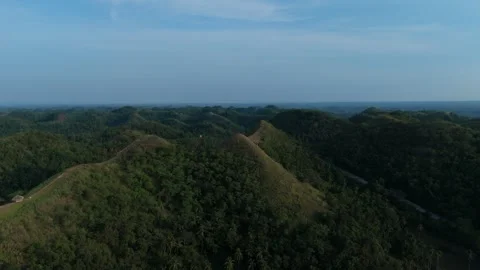 Dense forest covers the hills with a winding road visible below. Video stock 337253867