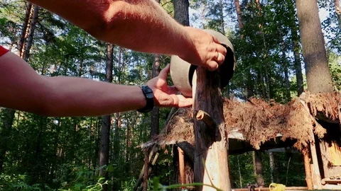 In a dense forest a man hangs a cooking pot on a stick 스톡 동영상 113947177
