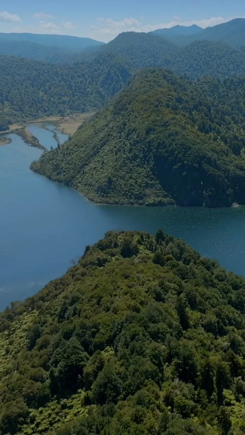 Dense forest surrounds a tranquil lake. Lake Waikaremoana, Te Urewera National Stock Footage 301410335