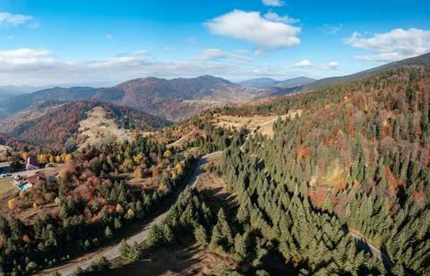 Dense forests on mountain peak under blue sky with clouds Stock Photos