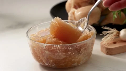 Dense gelatinous bone broth with collagen in a glass bowl; spoon-tested, Stock Footage 344031587