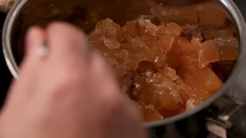 Dense, gelatinous bone broth cooled and tested with a spoon for collagen-rich Stock Footage 344031593