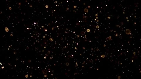Dense golden glitter particles falling against a black background Stock Footage 329598853