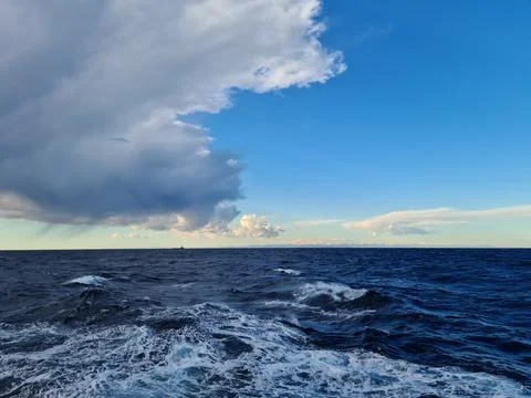 Dense gray cumulus clouds over the water surface of the sea Stock-Fotos