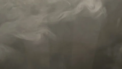 Dense gray smoke creates abstract shapes in front of a striped background Stock Footage 155450555