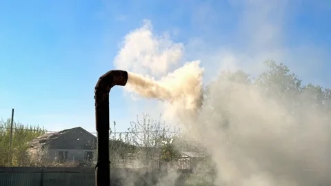 Dense gray smoke pouring from a curved metal chimney pipe on a barrel. Stock Footage 346055719