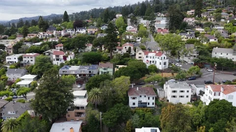 Dense hillside neighborhood with mixed rooftops, colorful homes, palm trees and Stock Footage 337669878
