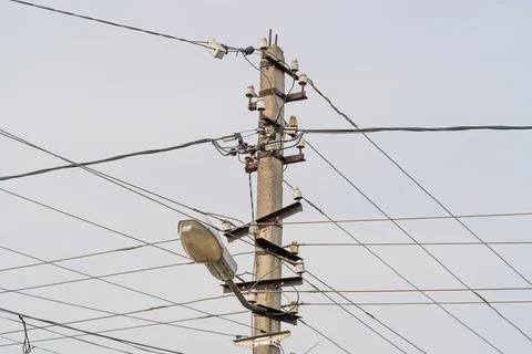 Dense network of overhead cables, converging at junction on utility pole, evo Stock Photos