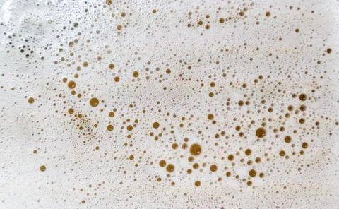 Dense pattern of dried brown liquid droplets spreading across a light worktop Stock Photos