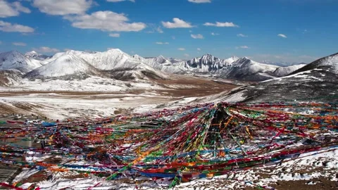 Dense prayer flags framing snowy mountain ranges in Tibet Stock Footage 345882797