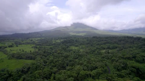 Dense rainforest spreads below misty Arenal Volcano in Costa Rica Vídeo Stock 345631534