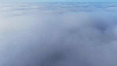 Dense, rolling layer of soft white clouds under a clear blue sky Stock Footage 334255974