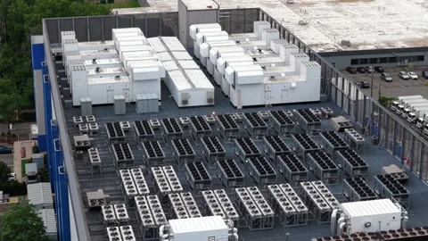 Dense rows of gray cooling units and large white backup generators cover data Stock Footage 340924902