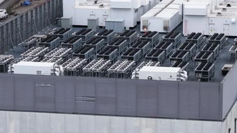 Dense rows of white cooling units and backup generators cover data center Stock Footage 340924946
