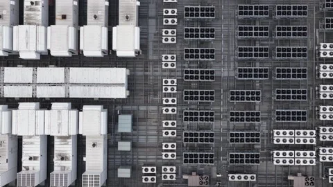 Dense rows of white cooling units and solar panels cover American data center Stock Footage 340925634