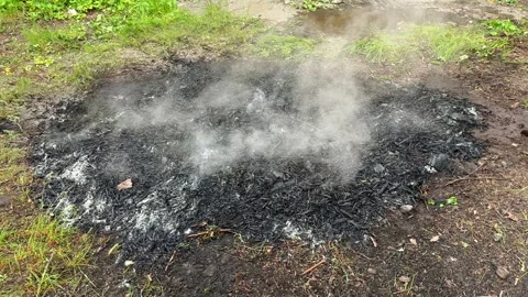 Dense smoke rising from burned bonfire remains Stock Footage 282532435