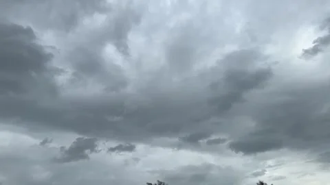 Dense storm clouds with dim sunlight breaking through Stock Footage 314708441