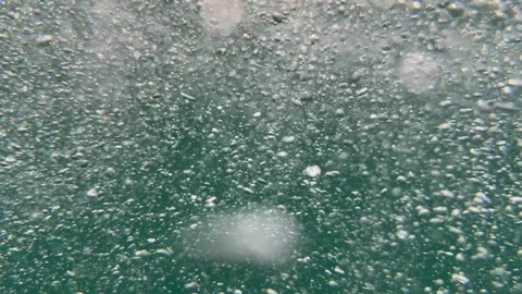 Dense stream of underwater air bubbles moves through seawater with shimmering Stock-Footage 335206185