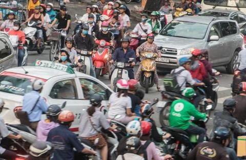 Dense traffic at intersection with passing through motorbikes and vehicles. Stock Photos