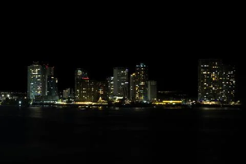 Dense urban development and illuminated apartment buildings along the coast.. Stock Photos