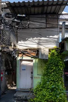 Dense utility cables above small house in Lumphini Bangkok Stock Photos