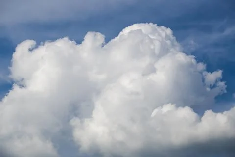 Dense white fluffy cumulus cloud formation in blue sky Stock Photos