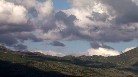 Densely clouds go over the mountain time lapse Stock Footage