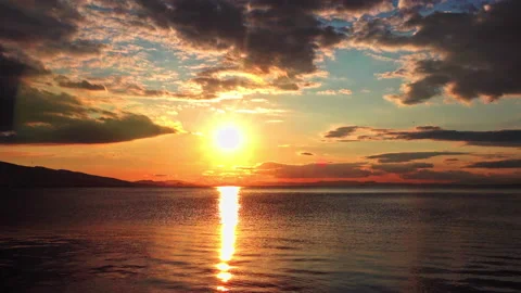 Densely Cloudy Yellow Sunset in Calm Ocean Water Stock Footage 161088324