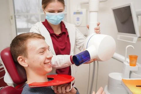 Dental assistant using x-ray machine on patient in dental clinic Foto stock