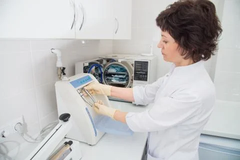 Dental assistent loading instrumenst for sterilization in sterilizer Foto stock