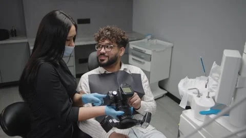 Dental clinic interaction between a patient and a technician with equipment Stock-Footage 320876897