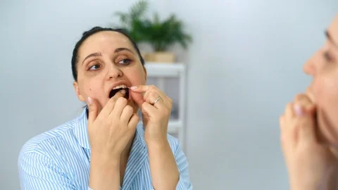Dental floss, brushing your teeth in the bathroom.Girl brushing her teeth. 4k 動画素材 124732370