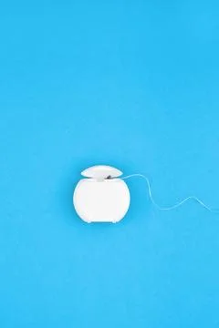 Dental floss container with thread on blue Stock Photos
