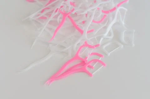 Dental floss on holders in pink and white colors. Healthy teeth concept. Stock Photos