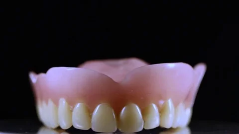 Dental jaw prothesis with white full teeth on black background. Stock Footage