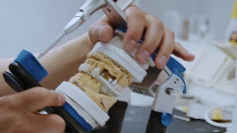 Dental Lab Professional Adjusting Upper and Lower Casts on a Mechanical Stockbeeldmateriaal 336627277