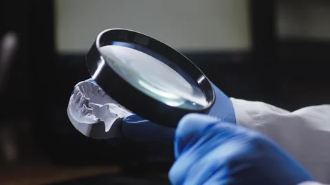Dental lab Technician inspects Ceramic teeth mould with magnifier Stock Footage 312661519