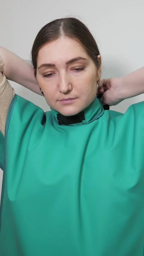Dental patient preparing for an x ray putting on a protective lead apron 스톡 동영상 344798805