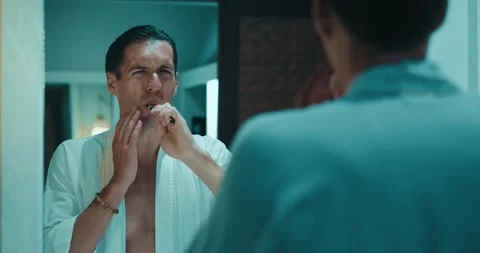 Dental problems and toothache. Reflection in the mirror millennial male in Stock Footage 251023139