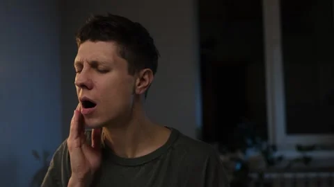 Dental problems. Young man touching cheek, closing eyes with expression of terri Stock Footage 296046052